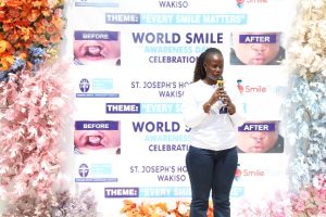 Audrey Linda, Programs Assistant at Smile Train, addressing guests during the World Smile Day celebrations at St. Joseph’s Hospital Wakiso.